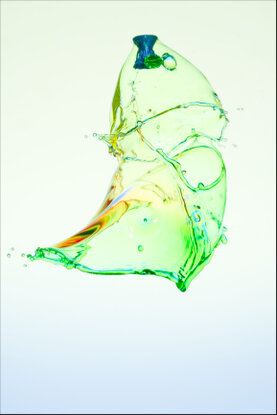 Farbige Wasserskuplturen, die aus 3 Tropfen mit einem Projektil durchstoßen wurden.