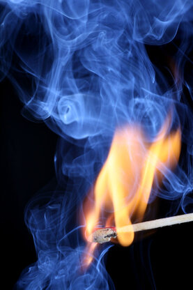 Darstellung eines zündenen Streichholzes mit Feuer und Rauch.