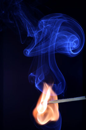 Darstellung eines zündenen Streichholzes mit Feuer und Rauch.